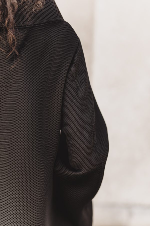 dekonstruirani crni kaput, od materjala ronilackog odijela, sa srebrnim ukrasima, kopca se na patent, ima džepove, iz nove kolekcije.
